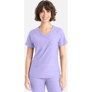 A lavender Y-neck top with short sleeves, featuring a logo on the front.