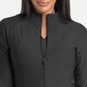 A full zip track jacket in dark grey featuring a sleek design and a zippered front, modelled by a person.