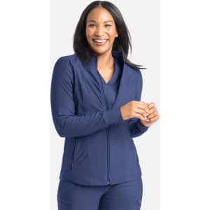 A full zip track jacket in navy blue, featuring a high collar and a fitted design. The model is smiling and wearing it.