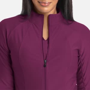 A full zip track jacket in a rich berry colour featuring a sleek design and a zipped front. It has a logo on it.