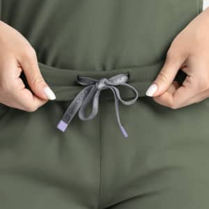 A close-up of olive green joggers with a grey drawstring tie. Includes a logo on the drawstring.