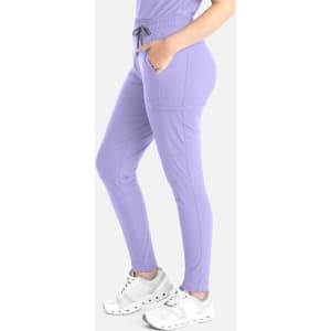 A pair of lavender tapered leg pants with side pockets, styled with a drawstring waistband and white sneakers.