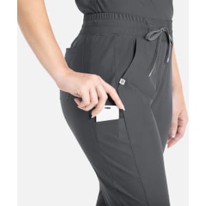 Grey tapered leg pants with pockets, featuring a hand reaching for a phone in the side pocket.