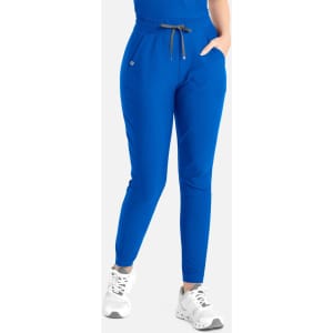 Blue tapered leg pants with elastic waistband and pockets, featuring a branding logo. Worn with white sneakers.
