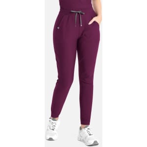A pair of tapered leg pants in deep purple, featuring an elastic waist and side pockets, paired with white sneakers.