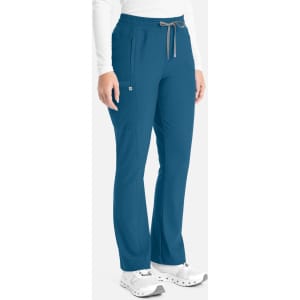 A pair of teal bootcut pants with a drawstring waist, featuring pockets and a branding logo on the side.