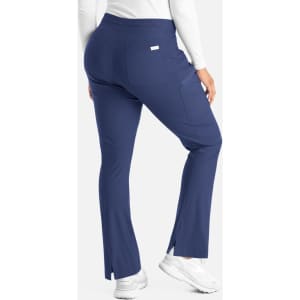 A pair of navy blue bootcut pants with side slits, featuring a waistband and a small branding logo on the back.