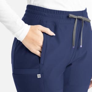 A blue bootcut pant with an elastic waistband and pockets, featuring subtle branding on the side.