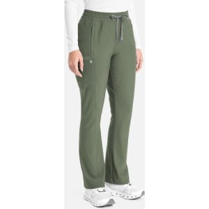 A person wearing olive green bootcut pants with a drawstring waist, side pockets, and white sneakers.