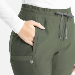 A bootcut pant in olive green with a drawstring waist and pockets, featuring a logo on the side.