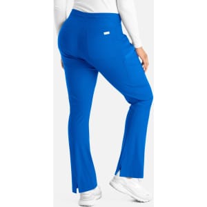 A pair of blue bootcut pants with a waistband and side slits, featuring a logo on the back pocket.