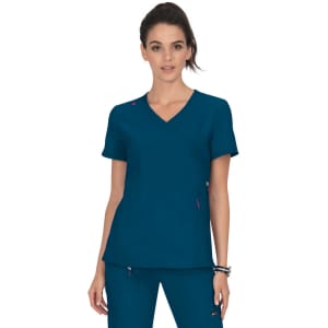 A teal scrub top with a v-neck, featuring a logo and pink accents, worn by a model.