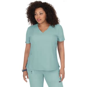 A woman wearing a light teal scrub top with a v-neck design. The top features a logo.
