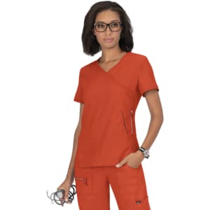 An orange scrub top is worn by a woman with glasses, featuring a V-neck and zippered pockets.