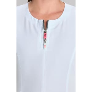 A close-up of a white top featuring a short zippered neckline and a subtle texture, showcasing a stylish design.