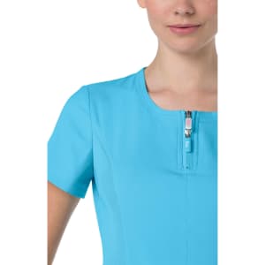 A close-up of a women's top in bright blue, featuring a zippered neckline and short sleeves. There's a logo on the fabric.