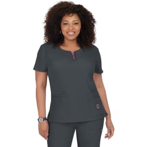 A woman models a dark grey medical scrubs top with a zip neckline and two pockets. It features a logo on the side.