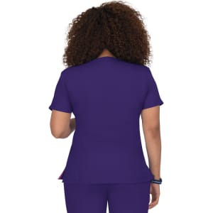 A woman wearing a purple top with short sleeves is seen from behind. The garment has a logo.