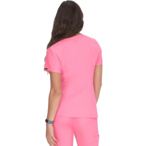 A woman wearing a bright pink top, viewed from the back, with a logo on the sleeve.