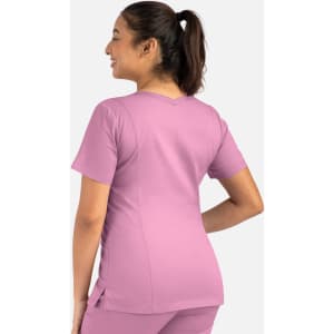 A women's double V-neck top in a light pink colour, featuring a fitted design and short sleeves, with a logo on it.