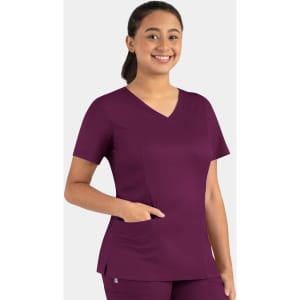 A woman in a purple double V-neck top with short sleeves and a pocket, featuring a logo.