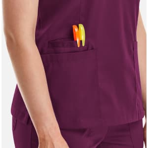 A purple women's double V-neck top featuring a side pocket with pens. The top has a logo on it.