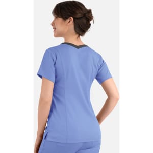 A women's double V-neck top in blue with a contrasting back and short sleeves. The top features a logo.