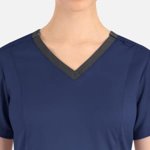 A navy blue women's top featuring a contrast double V-neck and grey trim. The design includes a logo.
