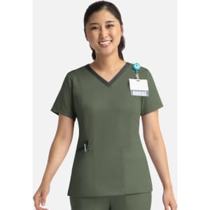 A nurse in an olive green double V-neck top with a dark trim, featuring a badge and logo.
