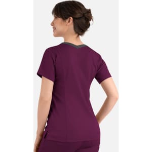 A womens top in dark purple with a double V-neck and contrasting grey detailing at the back. It features a logo.