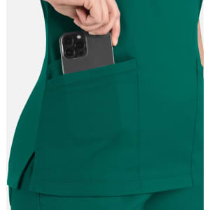 A close-up of a teal women's top with a pocket holding a smartphone. The fabric has a smooth texture.