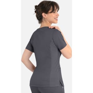 A woman wearing a grey curved mock wrap top, viewed from the back, with a sleek design and a logo present.