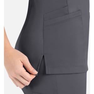 A women's curved mock wrap top in grey with pocket detail and side slits for added comfort.