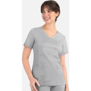 A woman in a light grey curved mock wrap top with short sleeves, featuring two front pockets.
