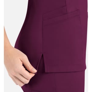 A close-up of a women's curved mock wrap top in deep burgundy, featuring pockets and side slits.