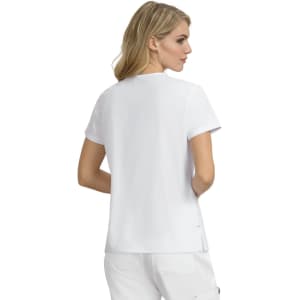 A woman is wearing a plain white short-sleeved top, viewed from the back. The top features a logo.