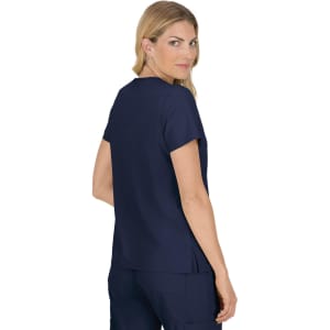 A woman wearing a navy blue top, viewed from the back, featuring short sleeves and a relaxed fit.