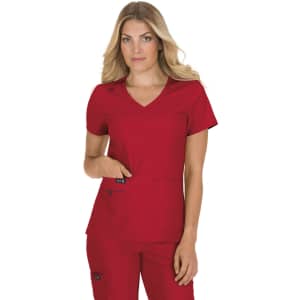 A woman wearing a red scrub top with a v-neck and two pockets, featuring a logo on one pocket.
