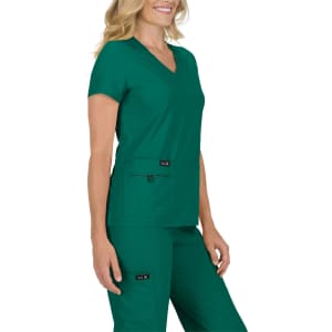 A green scrub top with short sleeves and a V-neck, featuring two front pockets and a branding logo.