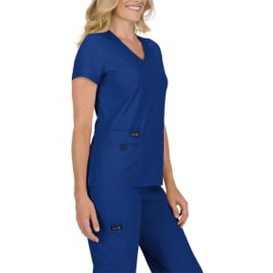 A woman wearing a navy blue scrub top with a V-neck and two front pockets, paired with matching pants.