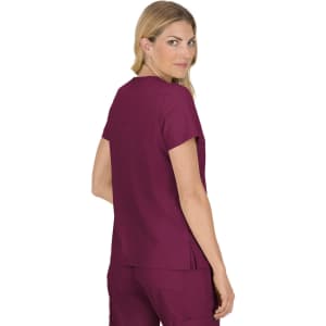A woman models a burgundy top with short sleeves, showing a back view. The top features a logo and a relaxed fit.