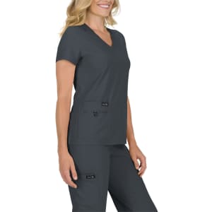 A woman wearing a charcoal grey scrub top with a V-neck and short sleeves, featuring two front pockets.