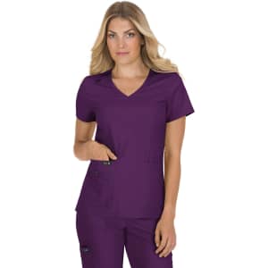 A woman wearing a purple top with a v-neck and pockets, showcasing a stylish design. The top has a logo.