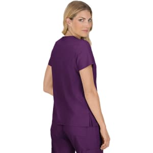 A woman in a purple top with a simple design, facing slightly back, features a logo on the fabric.