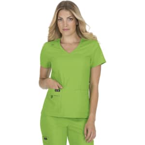 A medical scrubs top in bright green, featuring a V-neck and two front pockets, worn by a model.