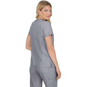 A woman wearing a grey medical top with short sleeves and a relaxed fit, featuring a subtle logo.