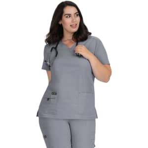 A grey medical top with a V-neck, featuring pockets and a logo, worn by a woman with shoulder-length hair.