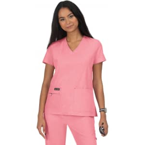 A pink scrub top with a V-neckline and two pockets, worn by a model with long dark hair.