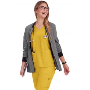 A woman wearing a grey jacket over a yellow top and pants, with a stethoscope around her neck.