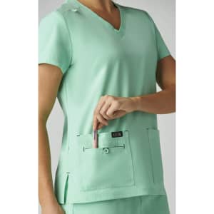 A mint green medical top with short sleeves and two front pockets, featuring a logo on one pocket.